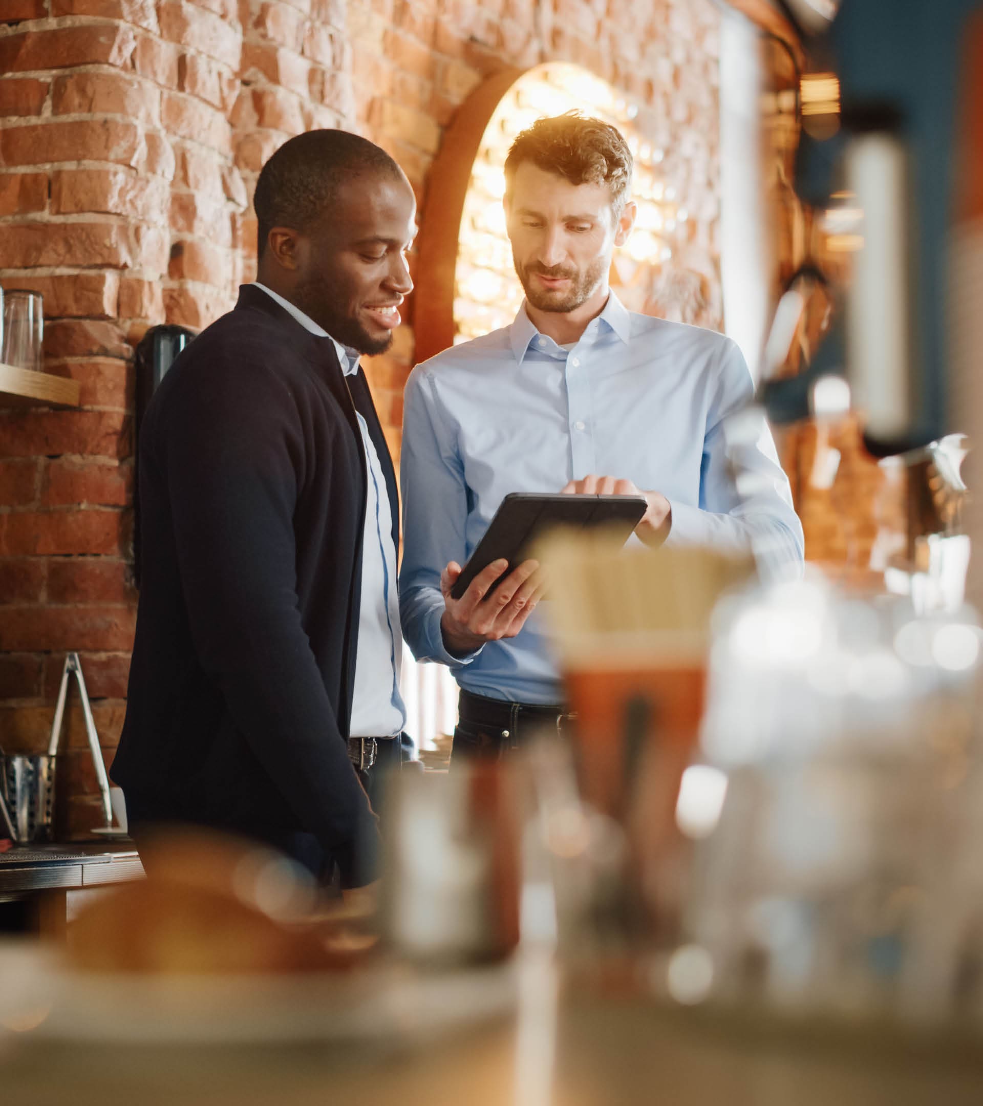 Multicultural Coffee Shop Owners Meeting Behind the Counter and Working on Tablet Computer and Checking Inventory in a Cozy Loft-Style Cafe. Successful Restaurant Managers and Barista at Work.; Shutterstock ID 1882428628; purchase_order: -; job: -; client: -; other: -