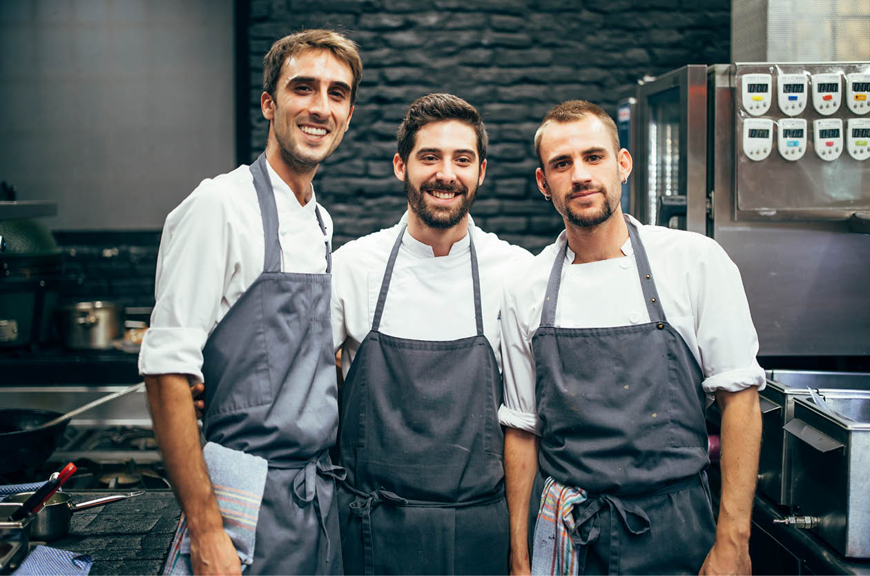 Portrait of three cooks in the kitchen of a restaurant